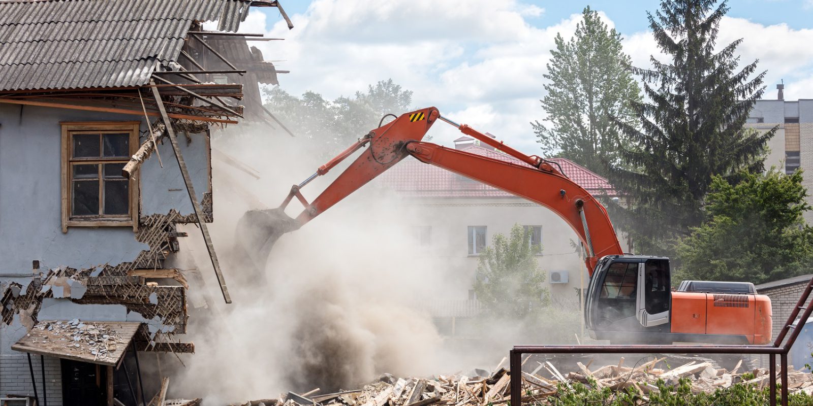 excavator working at the demolition of an old residential building